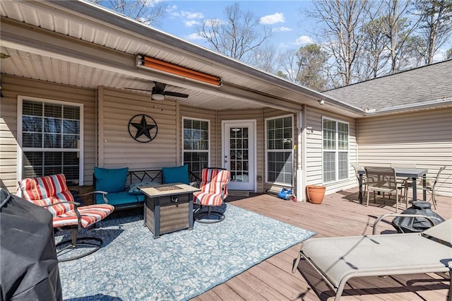 deck featuring an outdoor fire pit, a ceiling fan, and outdoor dining area