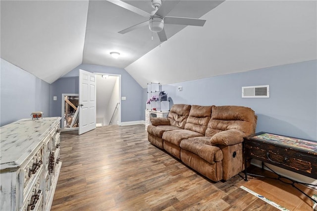 living area with visible vents, baseboards, wood finished floors, a ceiling fan, and vaulted ceiling