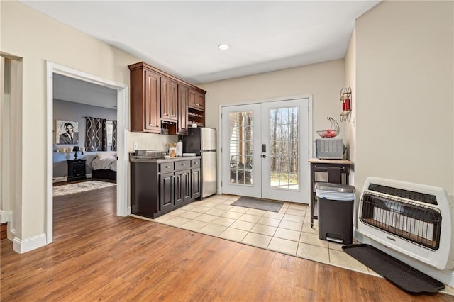 kitchen featuring heating unit, recessed lighting, french doors, light wood finished floors, and freestanding refrigerator