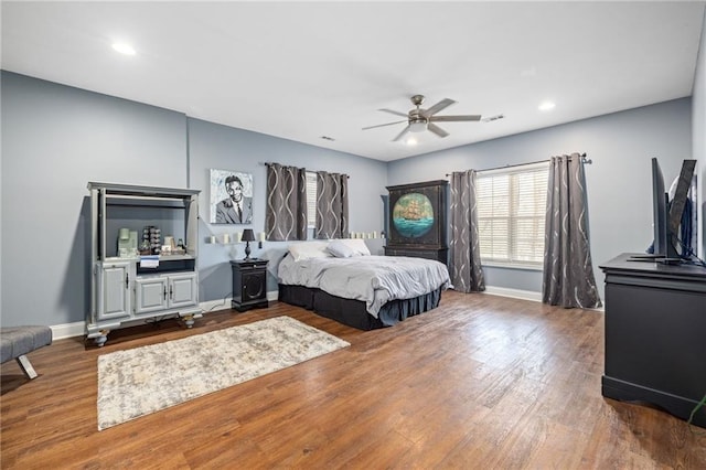 bedroom featuring baseboards, wood finished floors, and recessed lighting