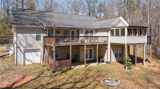 back of property featuring a patio area, french doors, a wooden deck, a sunroom, and a garage