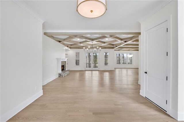 interior space with coffered ceiling, beam ceiling, and light wood-type flooring