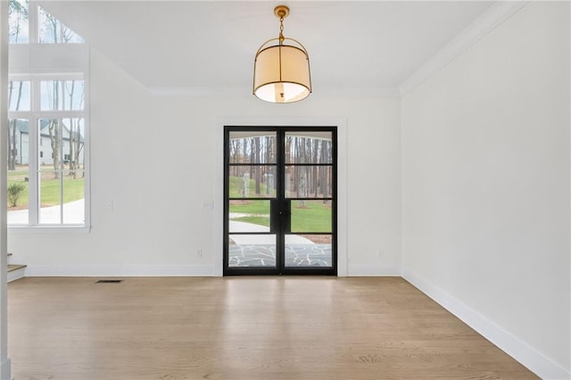 entryway with crown molding and light hardwood / wood-style floors