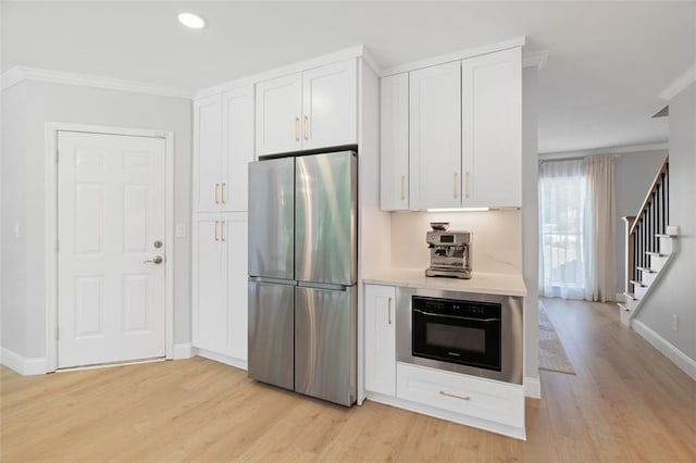 1661 Duxbury Ln NW, Kennesaw, GA 30152 - kitchen featuring freestanding refrigerator, wall oven, crown molding, light wood-style floors, and white cabinetry