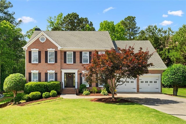 1661 Duxbury Ln NW, Kennesaw, GA 30152 - colonial home with concrete driveway, a front lawn, brick siding, and a shingled roof