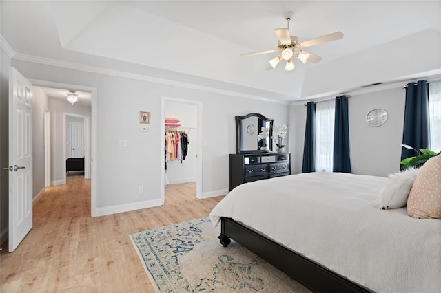 1661 Duxbury Ln NW, Kennesaw, GA 30152 - bedroom featuring a tray ceiling, light wood-style floors, baseboards, a spacious closet, and ornamental molding