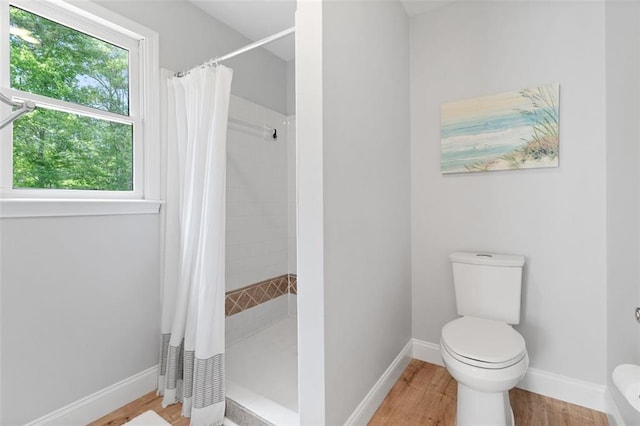 1661 Duxbury Ln NW, Kennesaw, GA 30152 - bathroom with toilet, a stall shower, wood finished floors, and baseboards