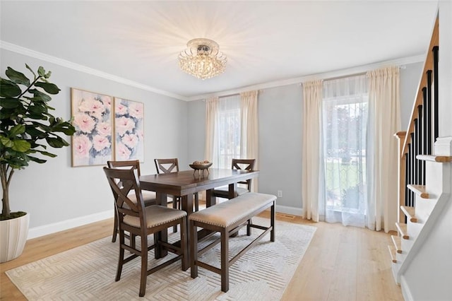 1661 Duxbury Ln NW, Kennesaw, GA 30152 - dining room featuring stairs, ornamental molding, a chandelier, light wood-type flooring, and baseboards