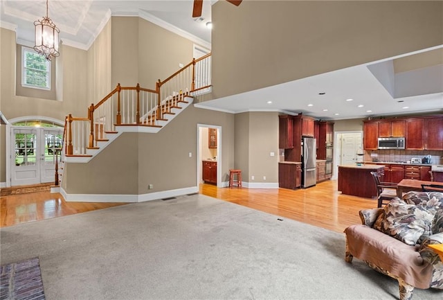 4842 Registry Dr NW, Kennesaw, GA 30152 - living room with healthy amount of natural light, light colored carpet, stairway, crown molding, and a towering ceiling