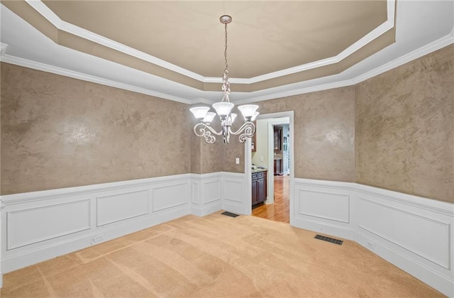 4842 Registry Dr NW, Kennesaw, GA 30152 - unfurnished dining area with a raised ceiling, light colored carpet, a chandelier, crown molding, and wainscoting