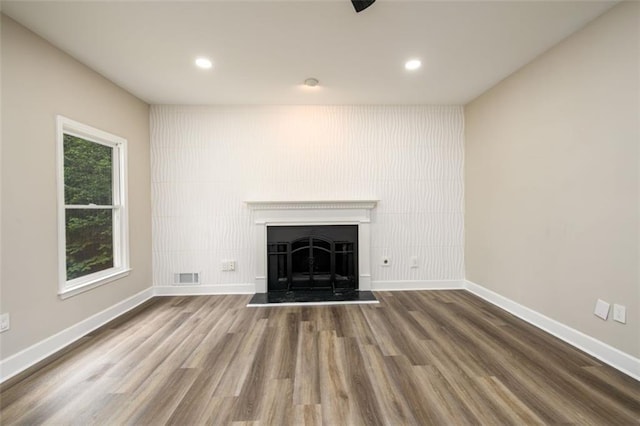 620 Reeves Hill Pt, Lawrenceville, GA 30043 - unfurnished living room with baseboards, wood finished floors, a fireplace with raised hearth, and recessed lighting