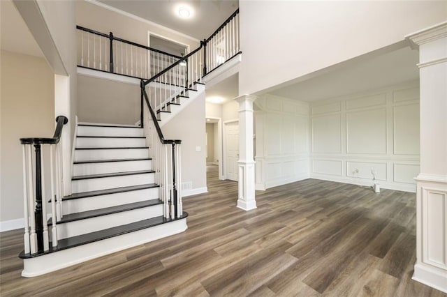 620 Reeves Hill Pt, Lawrenceville, GA 30043 - stairs with a high ceiling, wood finished floors, a decorative wall, decorative columns, and baseboards