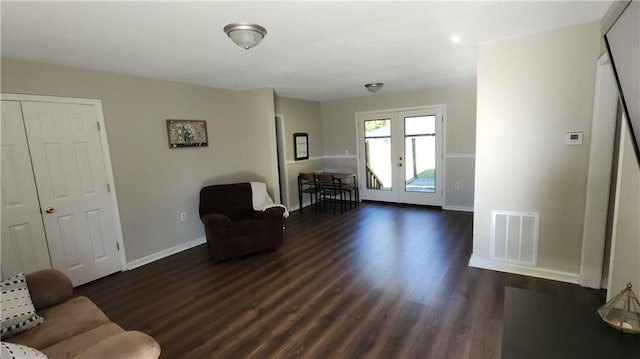 living area featuring baseboards, visible vents, dark wood finished floors, and french doors