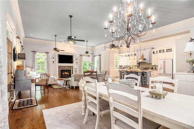 8901 Watkins Mill Rd, Winston, GA 30187 - dining room with a ceiling fan, dark wood finished floors, a stone fireplace, ornamental molding, and a chandelier