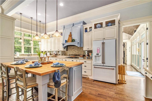 8901 Watkins Mill Rd, Winston, GA 30187 - kitchen with high end fridge, butcher block counters, wood finished floors, crown molding, and hanging light fixtures