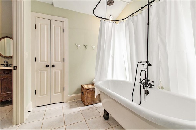 8901 Watkins Mill Rd, Winston, GA 30187 - full bath with tile patterned flooring, a freestanding bath, baseboards, vanity, and vaulted ceiling