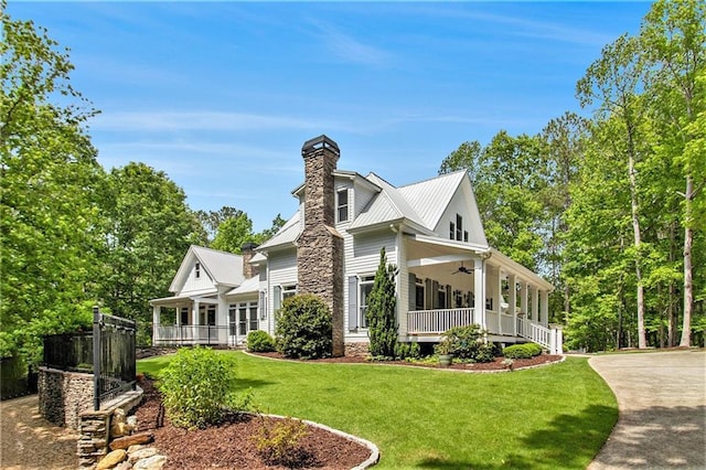 8901 Watkins Mill Rd, Winston, GA 30187 - view of side of home featuring covered porch, a ceiling fan, a yard, a chimney, and metal roof