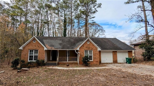 single story home featuring a porch and a garage