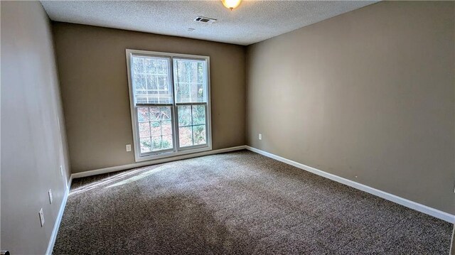 carpeted spare room featuring a textured ceiling