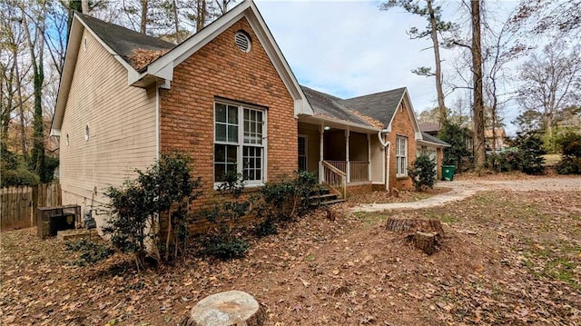 view of side of home featuring covered porch