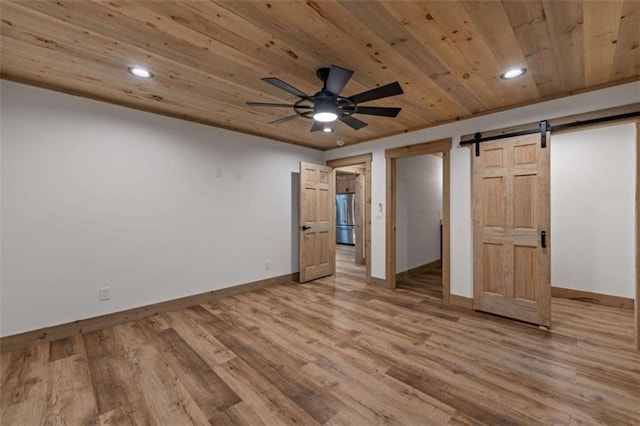 74 Cohutta Overlook Way, Blue Ridge, GA 30513 - unfurnished bedroom with freestanding refrigerator, a barn door, baseboards, wooden ceiling, and light wood-type flooring