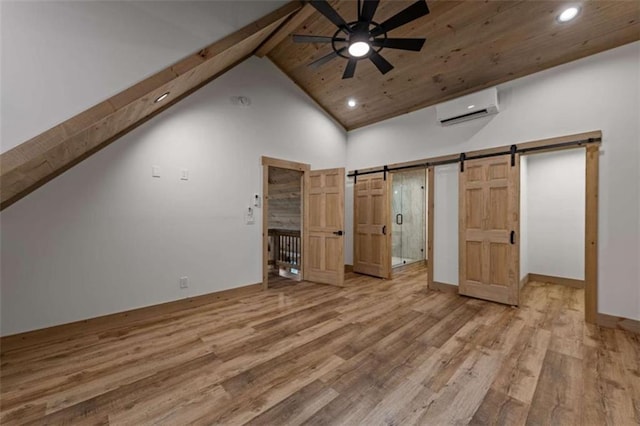 74 Cohutta Overlook Way, Blue Ridge, GA 30513 - unfurnished bedroom featuring a wall mounted air conditioner, a barn door, wood finished floors, beam ceiling, and recessed lighting