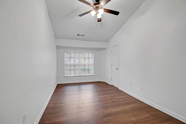 empty room featuring visible vents, baseboards, vaulted ceiling, a ceiling fan, and dark wood-style flooring