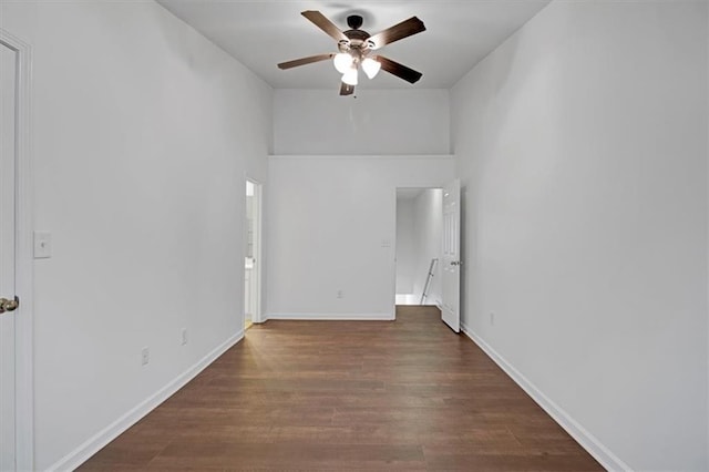 empty room with baseboards, wood finished floors, and ceiling fan