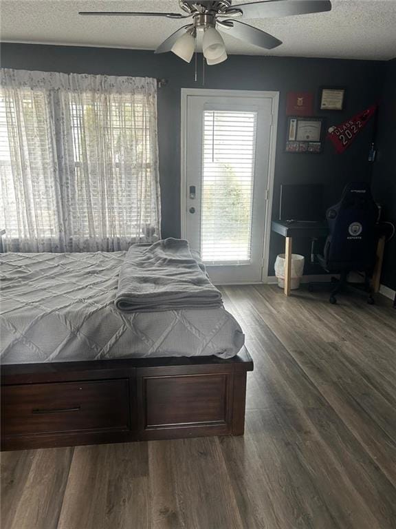 bedroom featuring ceiling fan, dark hardwood / wood-style floors, and a textured ceiling