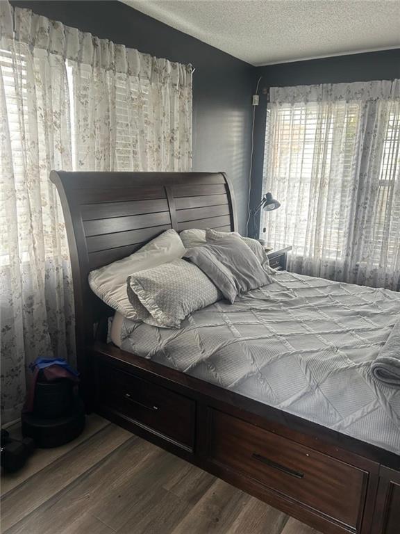 bedroom with wood-type flooring and a textured ceiling