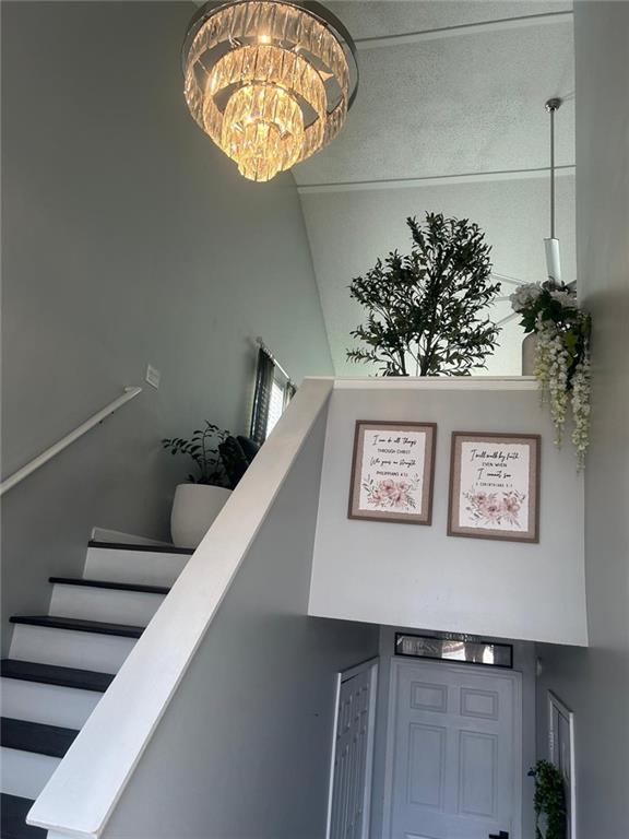 staircase with a high ceiling and an inviting chandelier