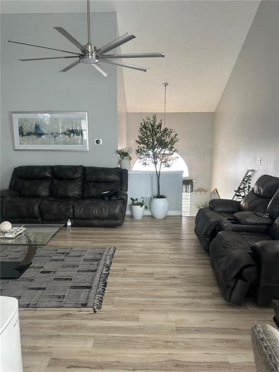 living room featuring high vaulted ceiling, light hardwood / wood-style floors, and ceiling fan