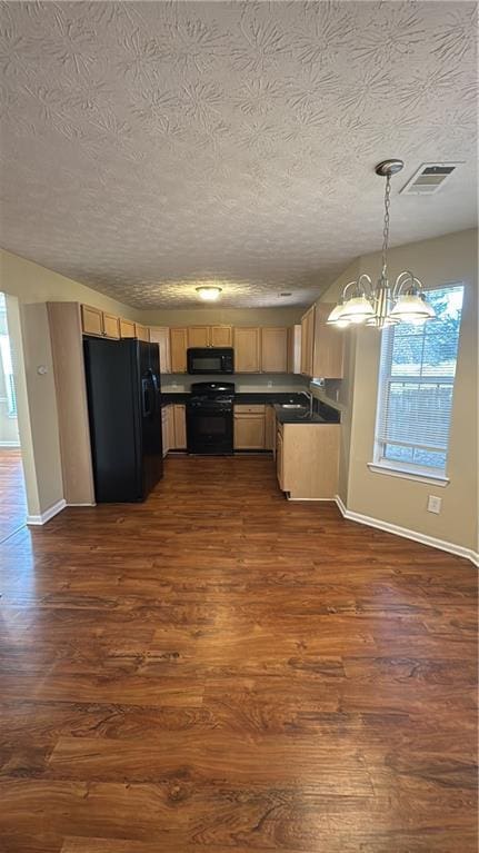 kitchen featuring a notable chandelier, pendant lighting, black appliances, dark wood-type flooring, and a textured ceiling