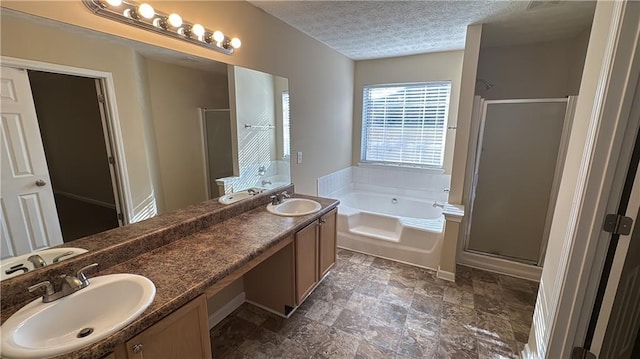 bathroom featuring a textured ceiling, vanity, and independent shower and bath