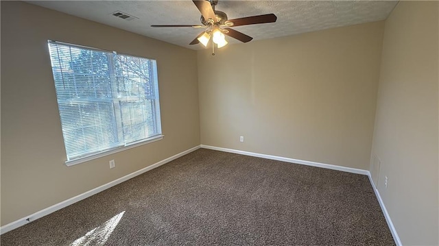 empty room with ceiling fan, carpet, and a textured ceiling