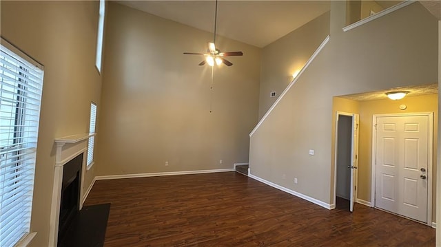 unfurnished living room featuring ceiling fan, dark hardwood / wood-style flooring, and high vaulted ceiling