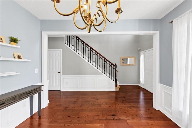 entrance foyer with a chandelier, wood finished floors, and stairway
