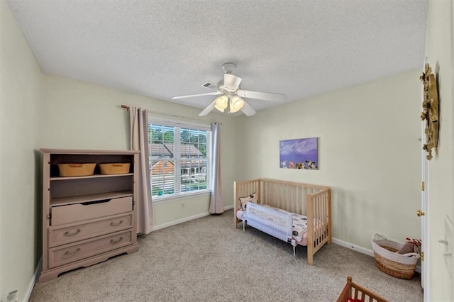 bedroom with a textured ceiling, baseboards, and carpet