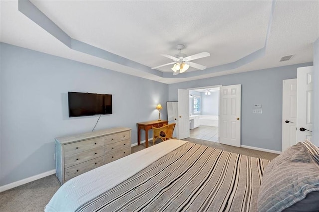 carpeted bedroom featuring ceiling fan, a textured ceiling, visible vents, a raised ceiling, and baseboards