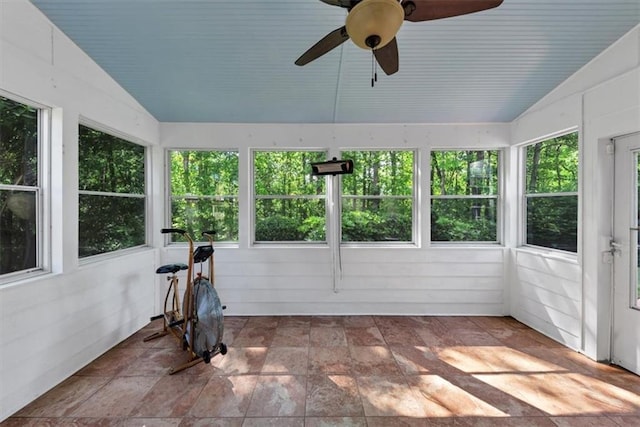 unfurnished sunroom with stone finish floor and lofted ceiling