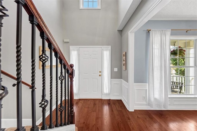 foyer with stairs, a high ceiling, and wood finished floors