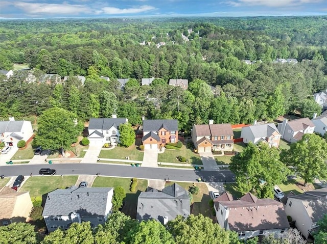 drone / aerial view featuring a residential view and a wooded view