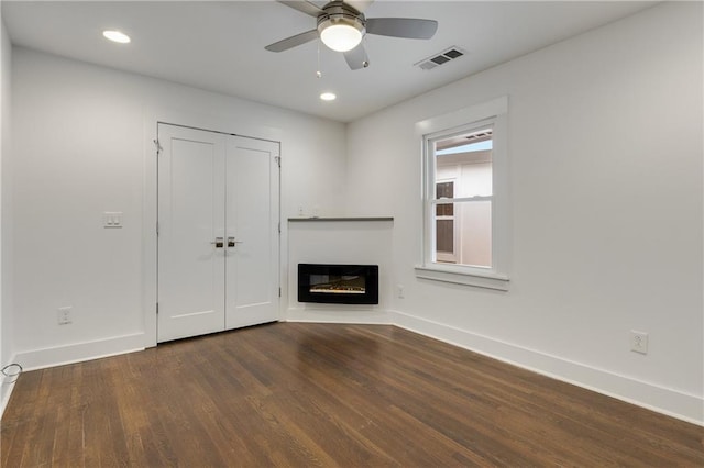 unfurnished living room featuring wood finished floors, baseboards, a glass covered fireplace, a ceiling fan, and recessed lighting