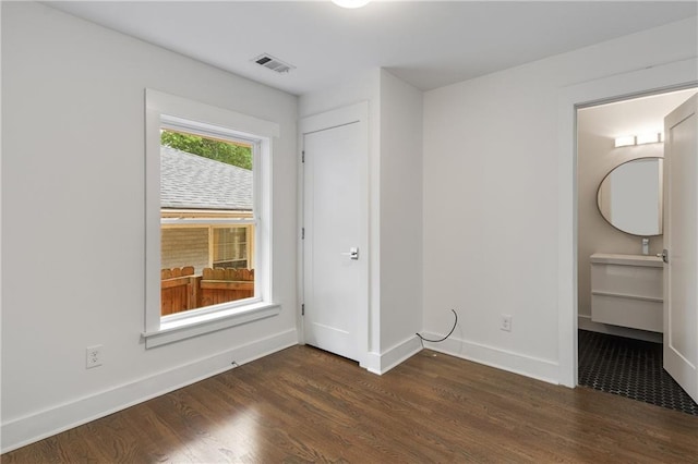 unfurnished bedroom with dark wood finished floors and baseboards