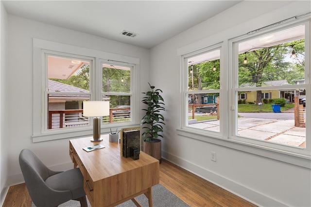 office featuring healthy amount of natural light, wood finished floors, and baseboards