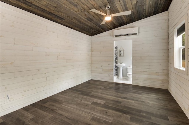 empty room featuring a wall mounted AC, vaulted ceiling, wood walls, ceiling fan, and dark wood-type flooring
