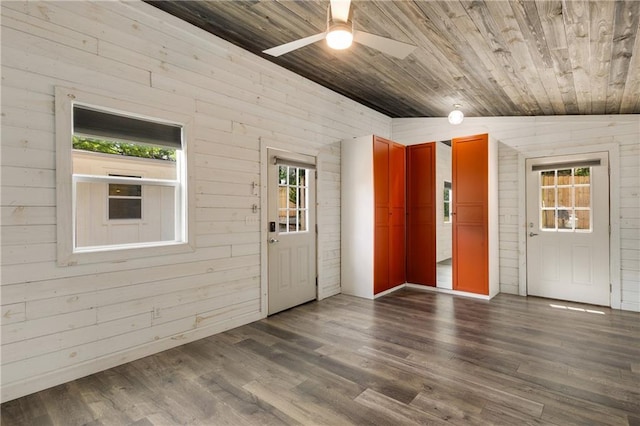 spare room with wood ceiling, a ceiling fan, dark wood-type flooring, and wood walls