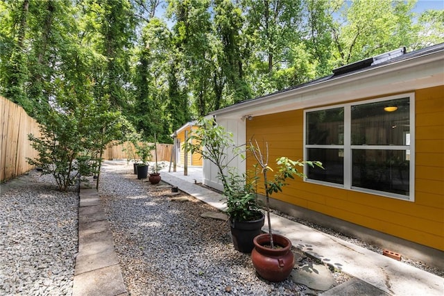 view of side of home with fence and a patio