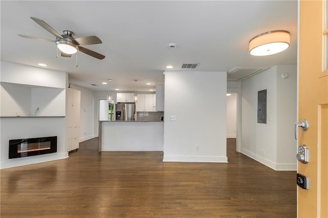 unfurnished living room with electric panel, dark wood finished floors, a ceiling fan, baseboards, and recessed lighting