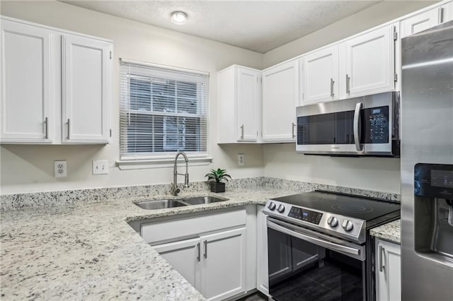 kitchen featuring light stone countertops, sink, white cabinets, and stainless steel appliances